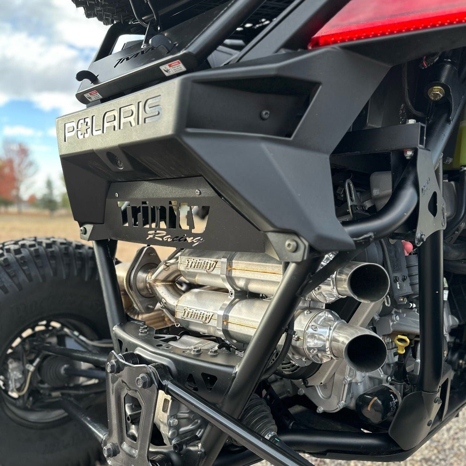Close-up of a Polaris vehicle with exhaust system and 'Rusher' branding.